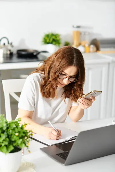 Middle-aged woman engrossed in laptop work at home. — Stock Photo