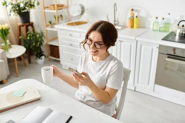 Una donna di mezza età si gode un momento di tranquillità sorseggiando un caffè a un tavolo. — Foto stock