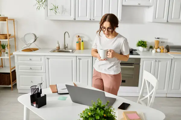 Frau mittleren Alters hält Tasse in Küche. — Stockfoto