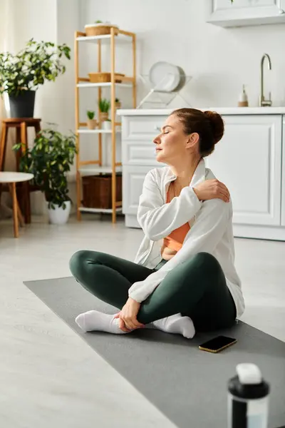 Middle-aged woman finding peace in a yoga session on a mat in a busy room. — Stock Photo