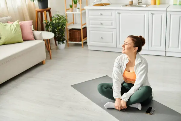 Femme d'âge moyen exercices yoga sur tapis dans le salon. — Photo de stock