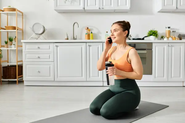 Frau mittleren Alters in Yoga-Pose plaudert am Telefon. — Stockfoto