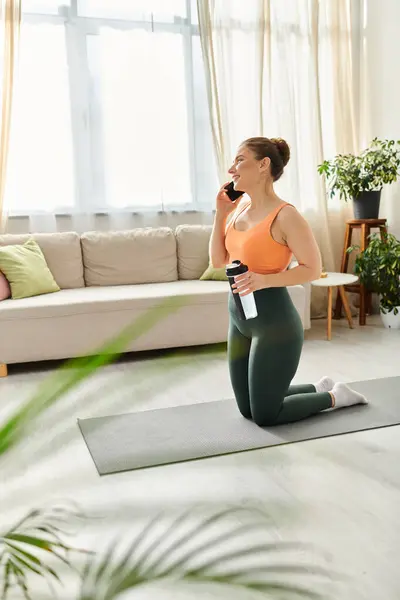 Middle-aged woman gracefully performing yoga pose in cozy living room. — Stock Photo