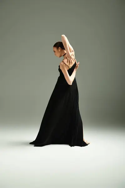 A young, beautiful ballerina in a black dress dances gracefully and energetically. — Stock Photo