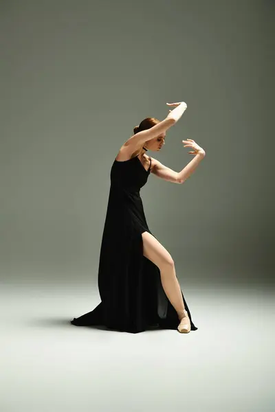 Молода, красива балерина в чорній сукні витончено танцює. — стокове фото