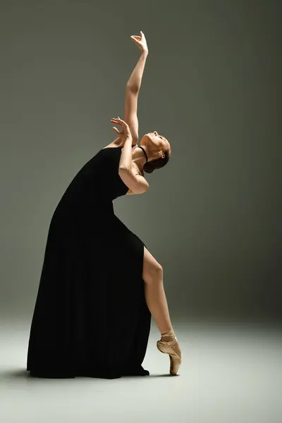 Giovane bella ballerina in abito nero in mostra posa danza. — Foto stock