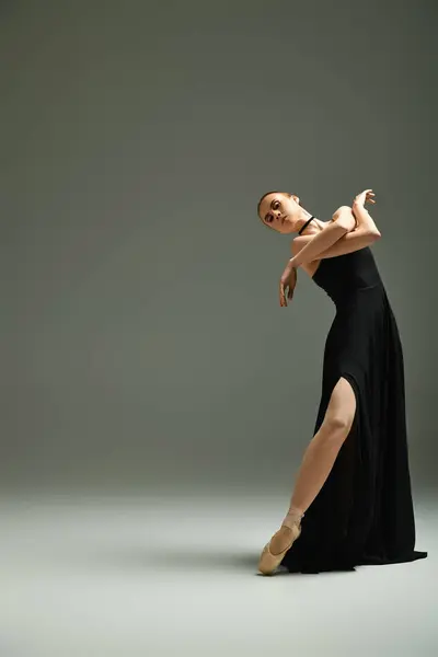 A young, talented ballerina gracefully dances in a stunning black dress. — Stock Photo