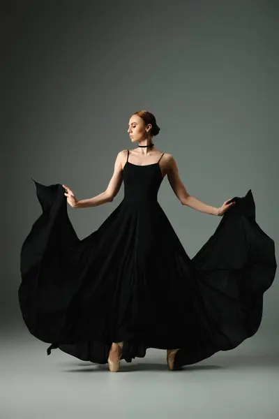 Young ballerina in black dress dancing gracefully. — Stock Photo