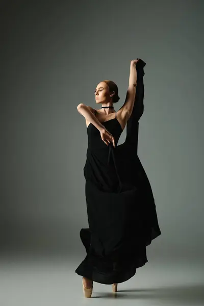 Junge Ballerina im schwarzen Kleid tanzt mit Anmut und Leidenschaft. — Stockfoto