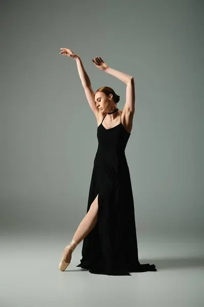 Young beautiful ballerina in black dress dances with grace and passion. — Stock Photo