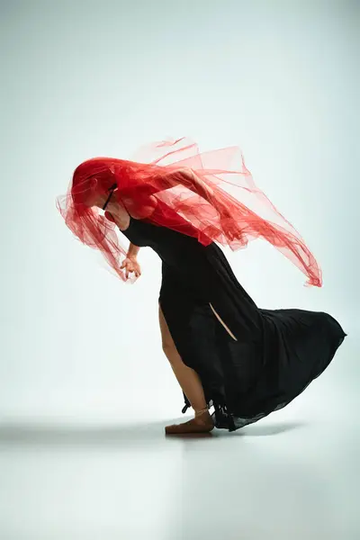 Une jeune belle ballerine dans une robe noire dansant gracieusement. — Photo de stock