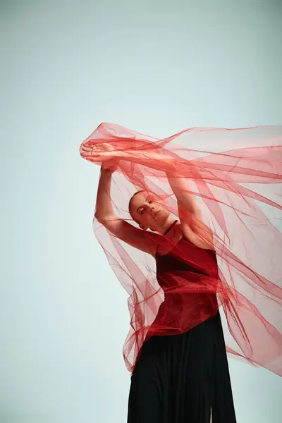 Una joven bailarina con un top rojo y falda negra baila con gracia en una actuación talentosa. - foto de stock