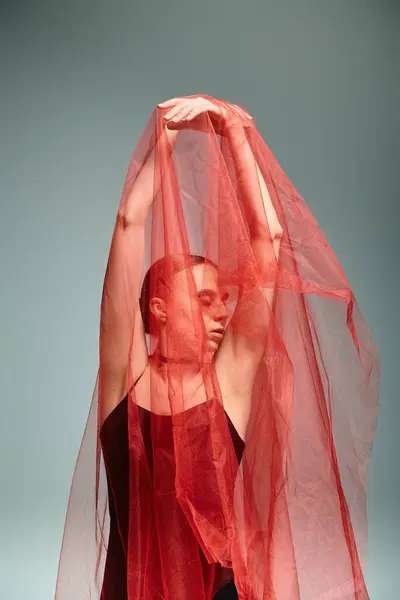 A young ballerina dances gracefully with a vibrant red veil on her head. — Stock Photo