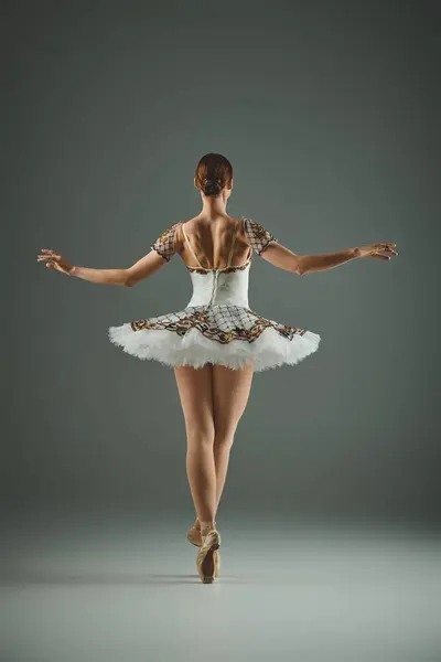 Молода балерина в білому турі витончено танцює. — стокове фото