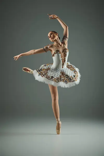 Молода, талановита балерина в білому турі і витончено танцює сукню. — стокове фото