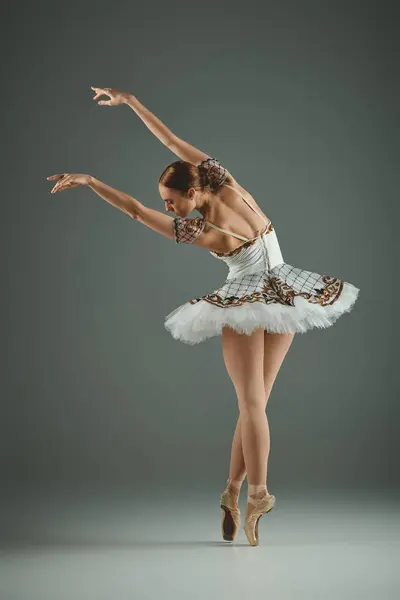 Молодая, красивая балерина в белой пачке и в трико, изящно танцующая. — стоковое фото