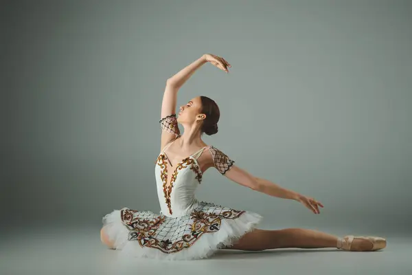 Talented young ballerina poses elegantly in a white dress. — Stock Photo