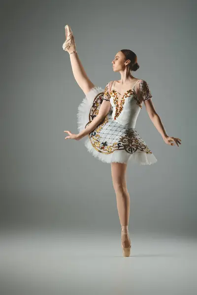 Молодая, красивая балерина энергично танцует в потрясающем белом и золотом платье. — стоковое фото