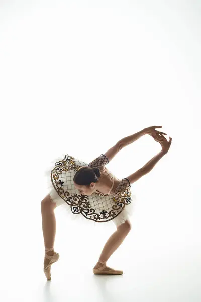 Eine junge schöne Ballerina tanzt anmutig in einem fließenden weißen Kleid. — Stockfoto