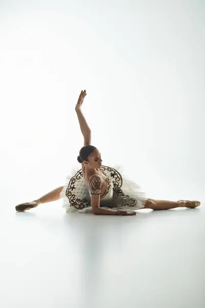 Jeune belle ballerine en robe blanche frappe une pose de danse dynamique. — Photo de stock