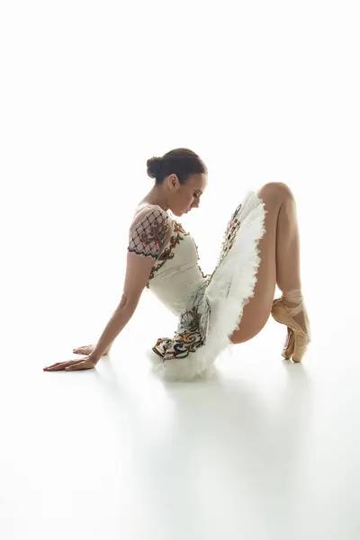 Una joven bailarina exhibe su talento en un vestido corto, golpeando una pose elegante. - foto de stock