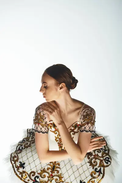 Talentierte Ballerina in einem atemberaubenden weiß-goldenen Kleid, das elegant tanzt. — Stock Photo