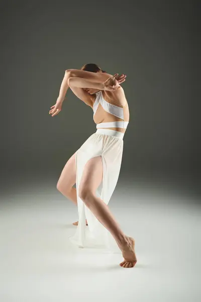A young, beautiful ballerina in a white dress dances gracefully. — Stock Photo