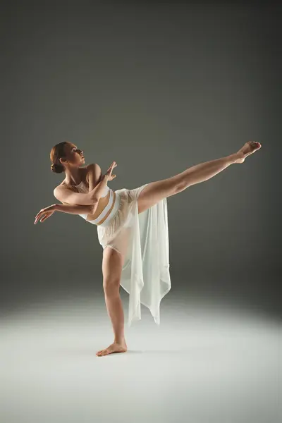 Junge Ballerina im weißen Kleid zeigt Anmut und Energie in dynamischer Tanzpose. — Stock Photo