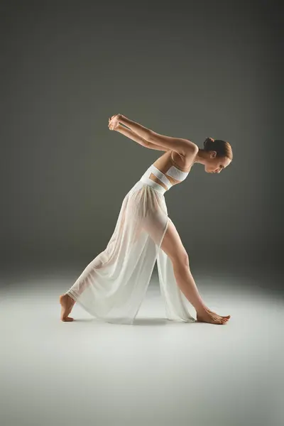 Eine junge, schöne Ballerina in einem fließenden weißen Kleid tanzt anmutig. — Stock Photo