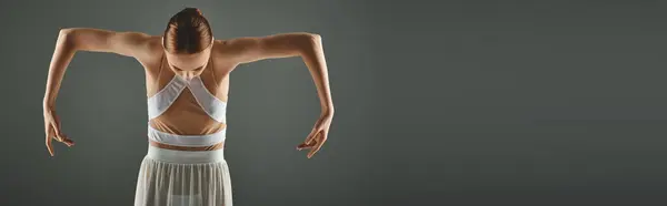Elegante bailarina posa con confianza en un vestido blanco, las manos en las caderas. - foto de stock
