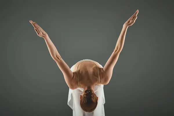 A young, beautiful ballerina with her hands raised elegantly in the air. — Stock Photo