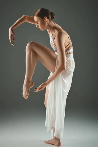 Um talentoso jovem bailarina em um vestido branco graciosamente executa um truque de dança cativante. — Fotografia de Stock
