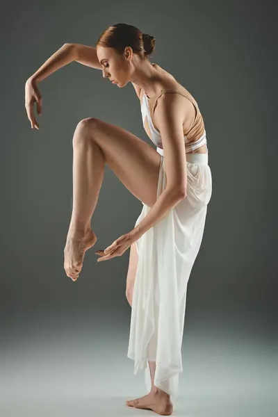 A talented young ballerina in a white dress gracefully performs a captivating dance trick. — Stock Photo