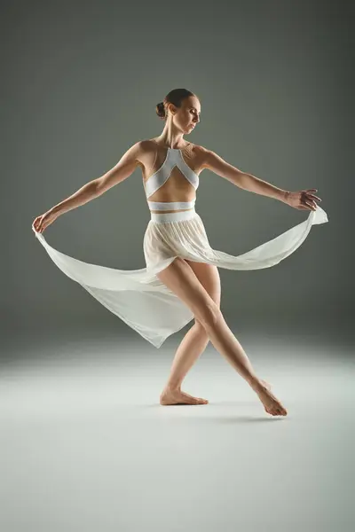 Young beautiful ballerina dancing gracefully in a white dress. — Stock Photo