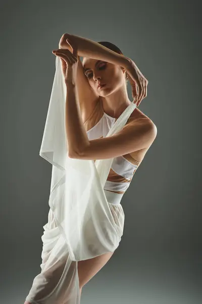 Молода балерина в білій сукні зачаровує своїм витонченим танцем завіси. — стокове фото