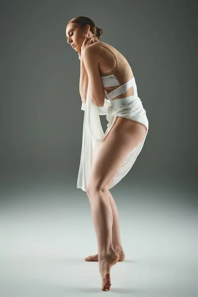 Graceful woman in white dress strikes a pose. — Stock Photo