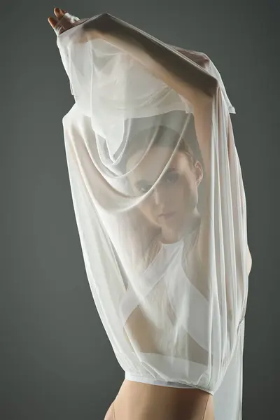 A young, beautiful ballerina in a sheer white dress with veil, gracefully dancing. — Stock Photo