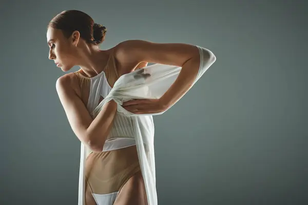 Una donna in costume da bagno tiene con grazia il velo in mano. — Foto stock