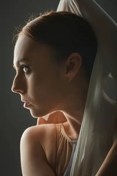 A young, beautiful ballerina gracefully dances with a veil draped over her head. — Stock Photo