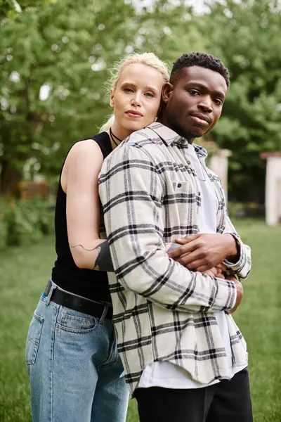 Un couple multiculturel heureux, un homme afro-américain et une femme caucasienne, se tiennent ensemble dans un beau champ. — Photo de stock