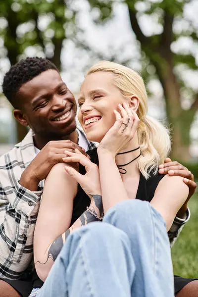 Un homme afro-américain joyeux et une femme blanche se tenant côte à côte dans un parc. — Photo de stock