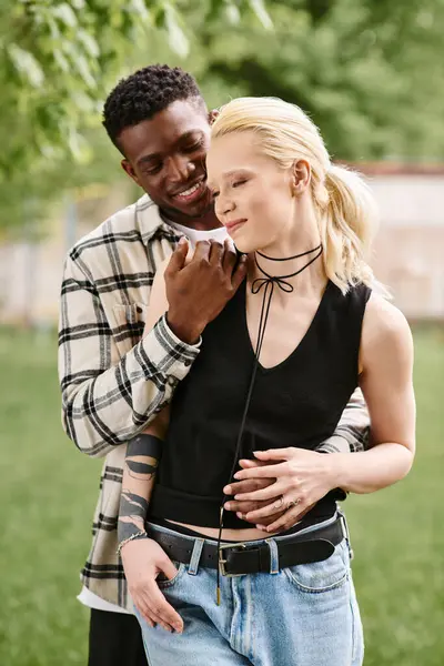 Un homme afro-américain et une femme caucasienne se tiennent ensemble dans un vaste champ, exsudant bonheur et unité. — Photo de stock