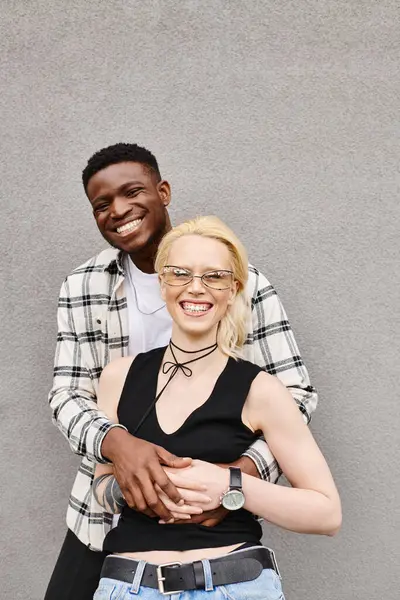 Un uomo e una donna multiculturali stanno insieme in una strada urbana, condividendo un momento di connessione e unità. — Foto stock