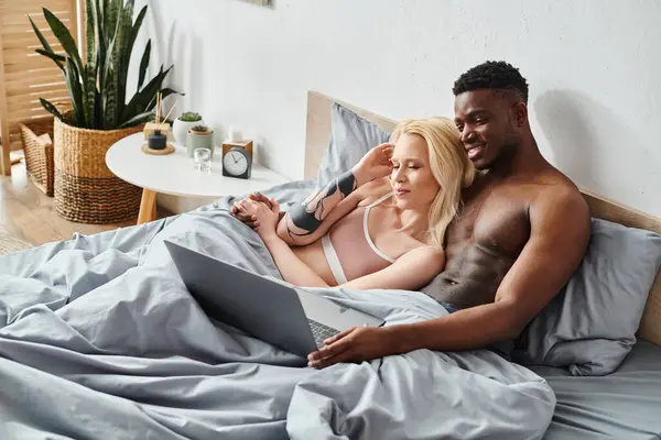 Un petit ami multiculturel et sa petite amie sont confortables et intimes, couchés ensemble paisiblement au lit. — Photo de stock