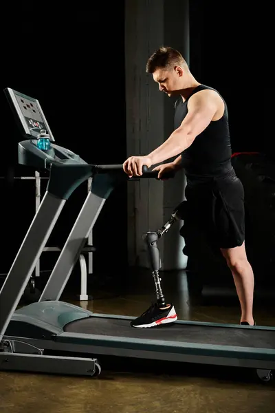 Un hombre discapacitado con una pierna protésica haciendo ejercicio en una cinta de correr - foto de stock