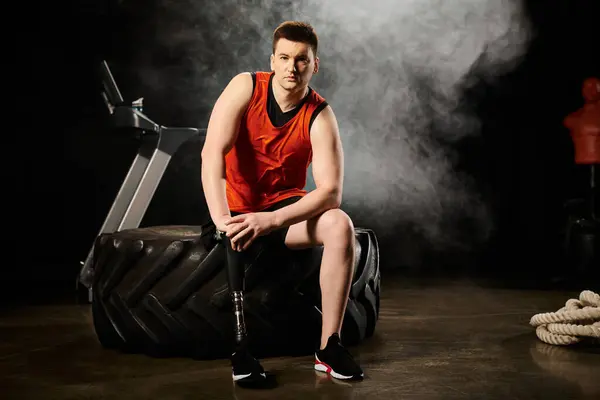 Ein Mann mit Beinprothese sitzt in entschlossener Pose auf einem Reifen. — Stockfoto