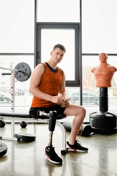 Ein behinderter Mann mit Beinprothese sitzt auf einer Gymnastikbank, konzentriert und entschlossen, zu trainieren. — Stockfoto