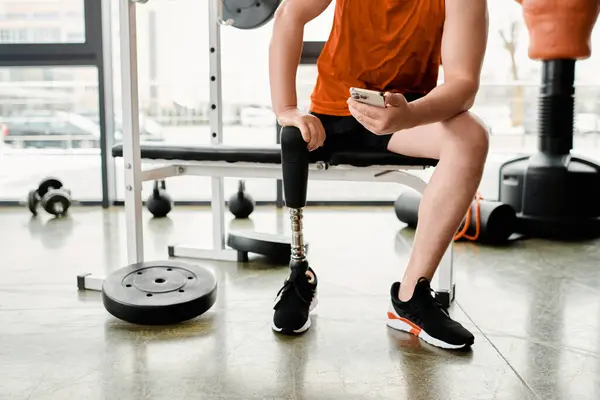 Athlète déterminé avec une jambe prothétique reposant au cours d'une séance d'entraînement de gymnase inspirante. — Photo de stock