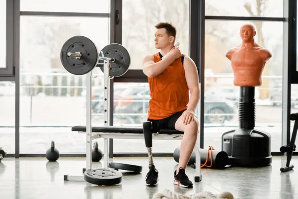 Um homem deficiente com uma perna protética encontrar consolo e força como ele se senta em um banco em um ginásio, contemplando seu treino. — Fotografia de Stock
