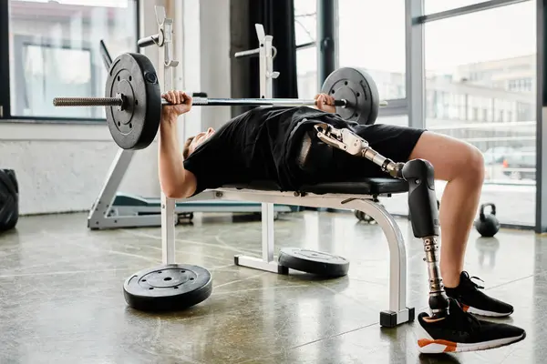 Ein Mann mit Beinprothese bezwingt in einem Fitnessstudio einen Bankdrücker mit einer Langhantel. — Stockfoto